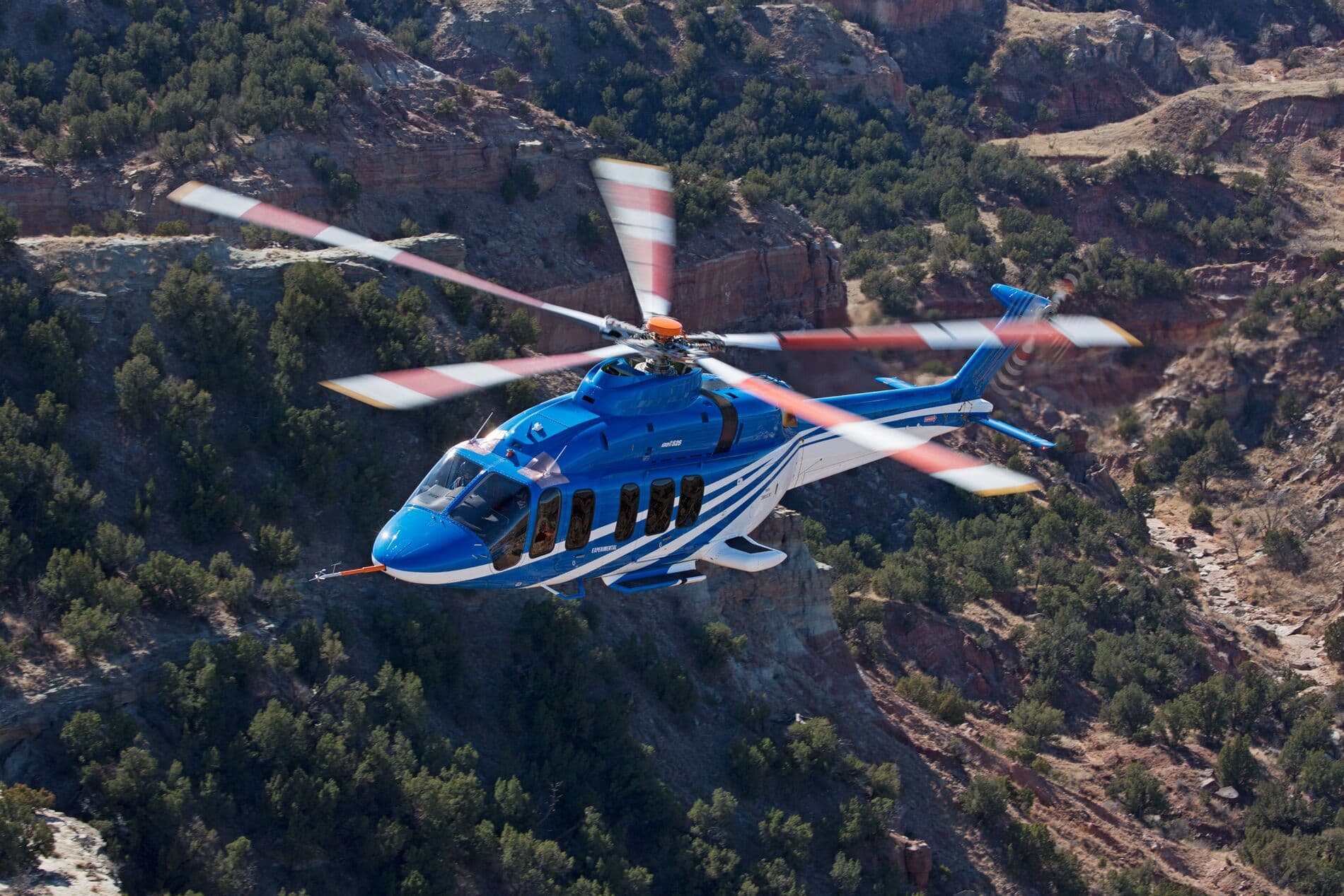Bell 525 en vol au dessus de montagnes vertes du désert